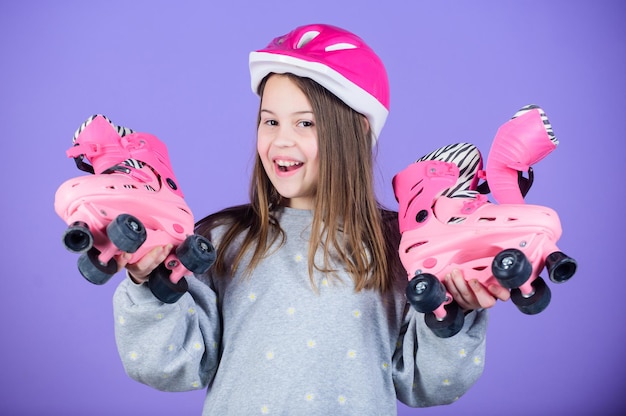 Photo ado joyeuse va patiner adolescente sportive fille adolescente mignonne porte un casque et des patins à roulettes sur fond violet en avant pour les aventures loisirs actifs et style de vie patin à roulettes passe-temps pour adolescents