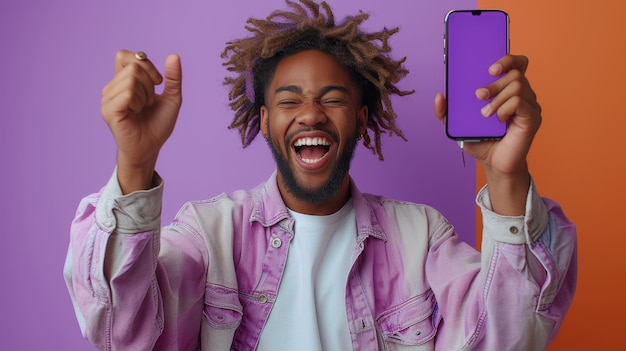 Photo un adolescent afro-américain saute avec son smartphone montrant un écran vide sur un fond orange avec de l'espace pour votre maquette de publicité mobile