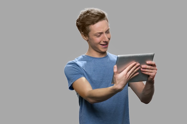 Adolescent à l'aide de tablette pc. Adolescent mignon ayant un chat vidéo avec des amis. Les gens, la technologie, la communication Internet.