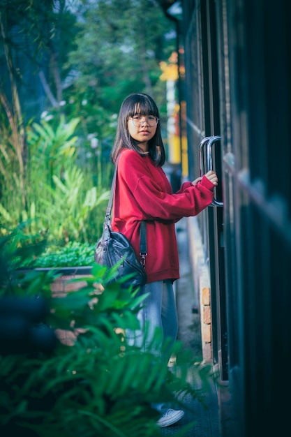 Adolescent asiatique debout contre la porte fermée