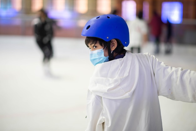 Photo un adolescent asiatique joue au patin à glace à l'intérieur