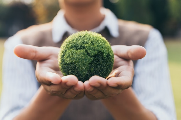 Photo adolescent asiatique montrant la terre à portée de main, l'écologie et le concept durable de l'environnement.