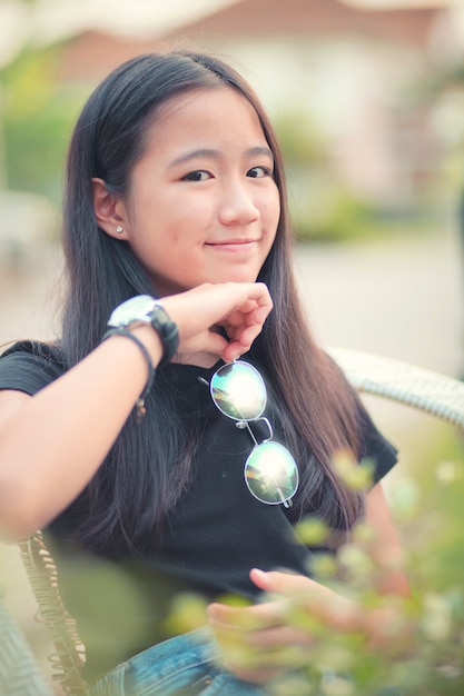 adolescent asiatique avec des yeux des lunettes poche contact avec les yeux en souriant le visage