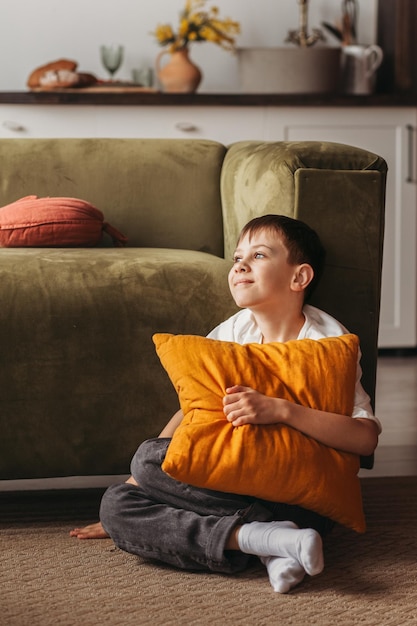 Adolescent assis dans le salon souriant se reposant après l'éducation