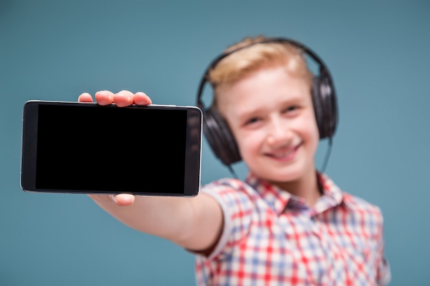 Photo adolescent avec un casque montre l'écran du smartphone