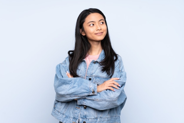 Adolescent, chinois, femme, bleu, mur, regarder, côté