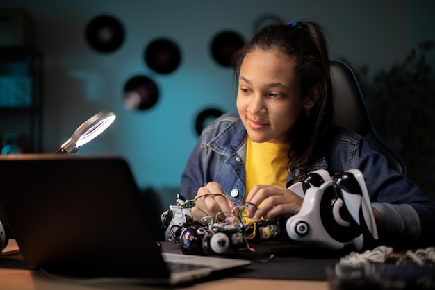 Un adolescent concentré a une formation en robotique à distance