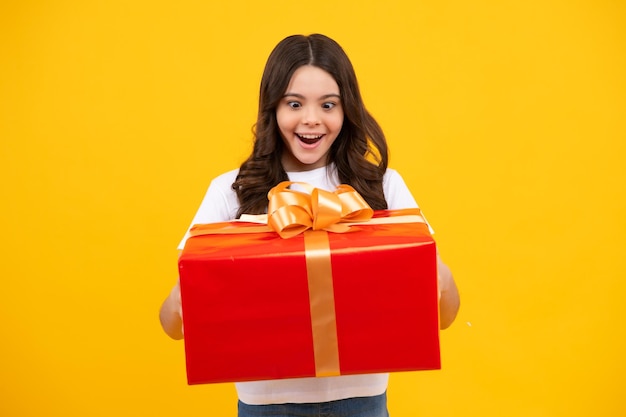 Adolescent émerveillé Enfant adolescent émotif tenir un cadeau pour l'anniversaire Fille drôle d'enfant tenant des boîtes-cadeaux célébrant la bonne année ou Noël Adolescente excitée