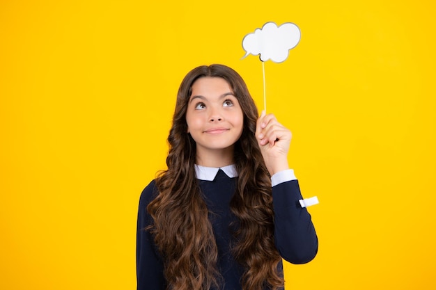 Adolescent enfant girl holding bulle de pensée nuage de commentaires sur fond jaune