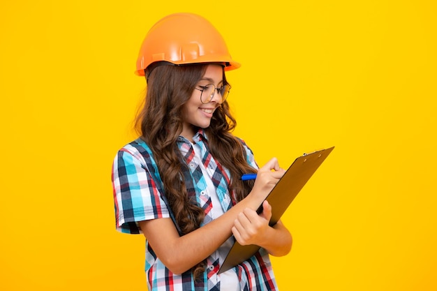 Adolescent enfant peintre en casque avec presse-papiers Enfant en casque Ingénieur enfant sur chantier Rénovation et réparation