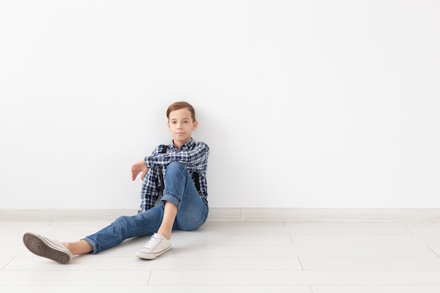 Adolescent, enfants et concept de mode - portrait d'un beau garçon de mode sur le mur blanc avec espace copie