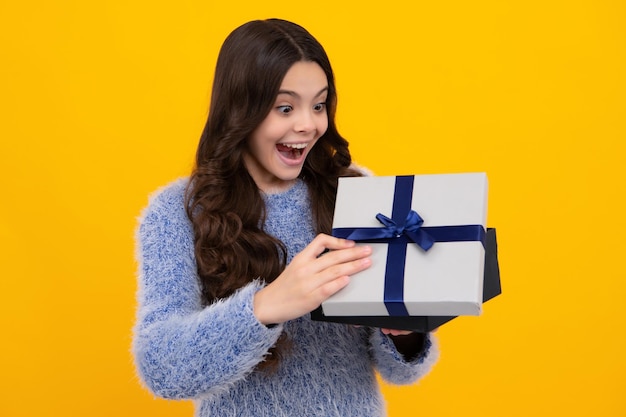Adolescent étonné Enfant avec boîte cadeau sur fond isolé Présente pour l'anniversaire Saint Valentin Nouvel An ou Noël Excité adolescente