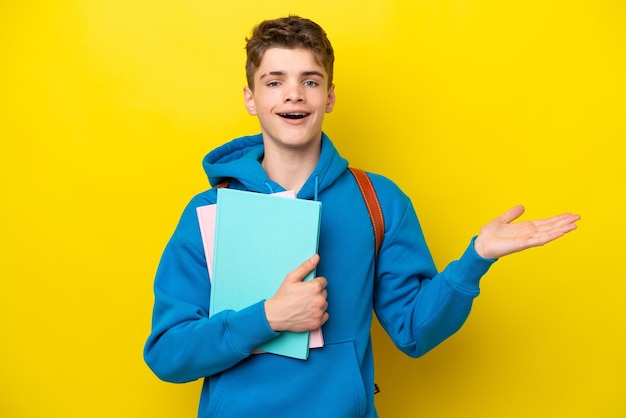 Adolescent étudiant russe homme isolé sur fond jaune avec une expression faciale choquée