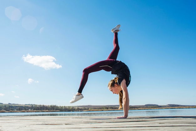 Adolescent, faire de la gymnastique sur la jetée