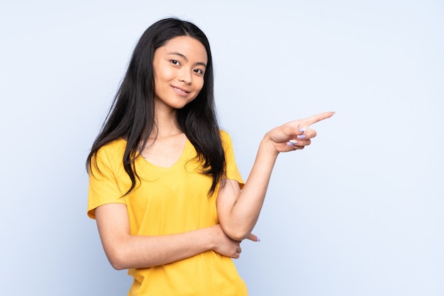 Adolescent femme chinoise isolée sur le doigt pointé bleu sur le côté