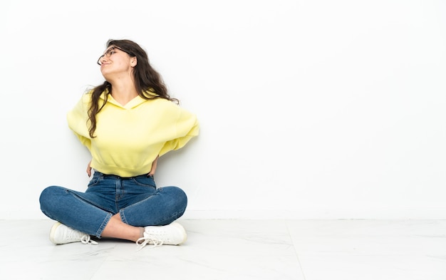 Adolescent femme russe assise sur le sol souffrant de maux de dos pour avoir fait un effort