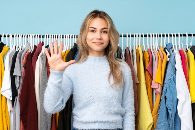 Adolescent fille russe acheter des vêtements isolés sur bleu
