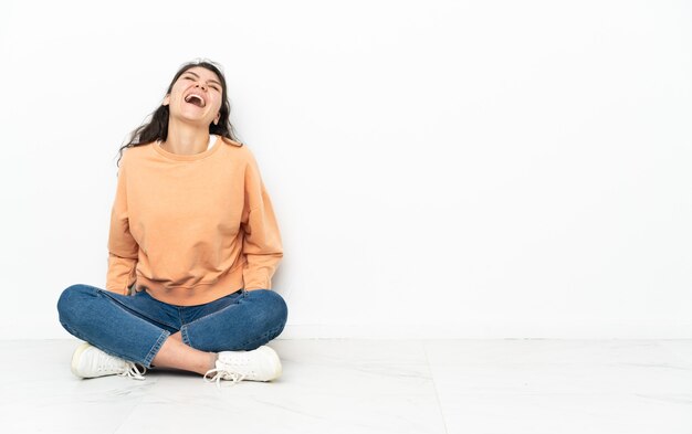 Adolescent fille russe assise sur le sol en riant