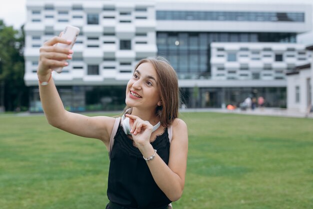 Adolescent gai jeune fille prenant selfie avec un casque.