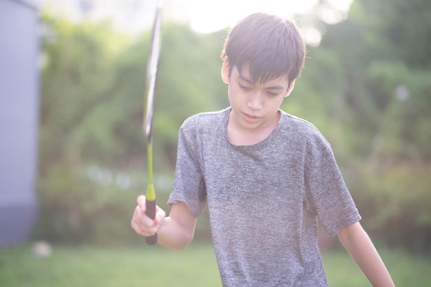 Photo adolescent garçon jouant au badminton parc extérieur extérieur