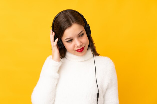 Adolescent, girl, isolé, sur, mur jaune, écoute, musique