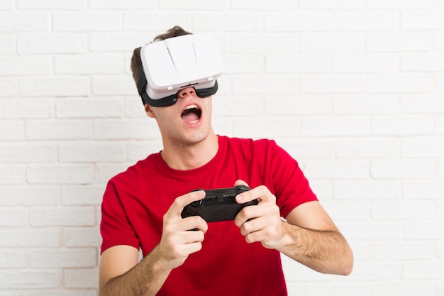 Adolescent homme caucasien à l'aide de lunettes de réalité virtuelle et contrôleur de jeu