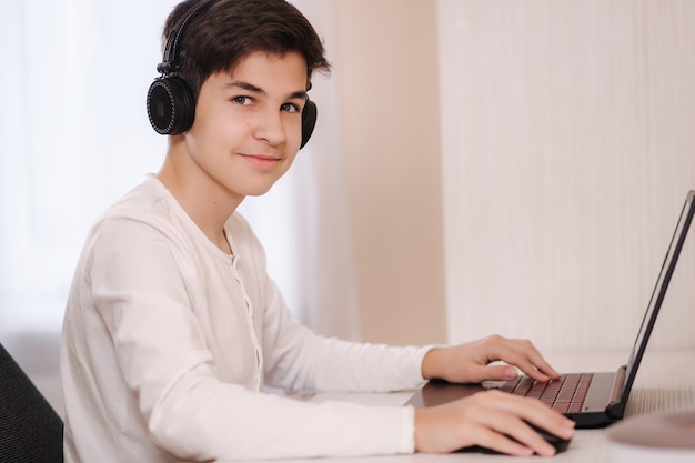 Adolescent, jeu de jeu sur son ordinateur pc dans la salle blanche