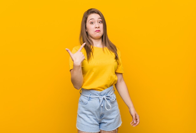 Adolescent de la jeune femme portant une chemise jaune pointant avec le doigt vers vous comme si vous vous invitiez à vous rapprocher.