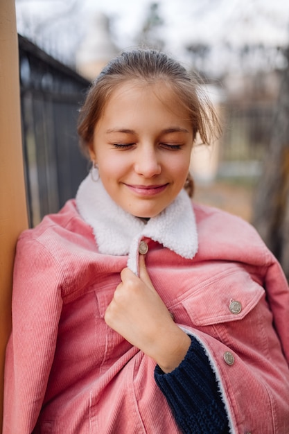 Photo adolescent de la jeune fille aux yeux fermés. adolescent, debout, parc, sourire, pensée