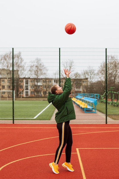 Adolescent jouant au basket en plein air