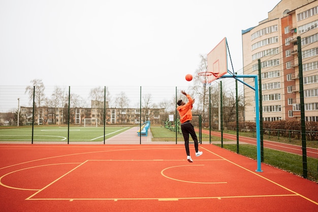 Photo adolescent jouant au basket en plein air