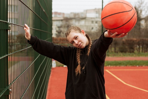 Photo adolescent jouant au basket en plein air