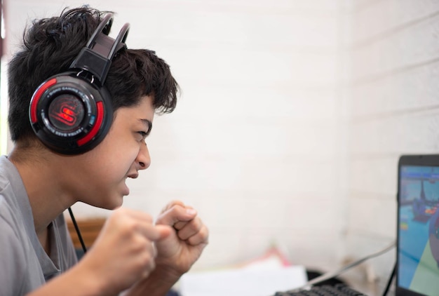 Photo adolescent jouant à un jeu d'ordinateur avec un casque