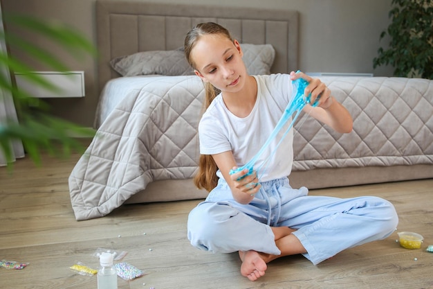 Un adolescent joue avec une boue bleue Concept de fille faite de goo fait maison