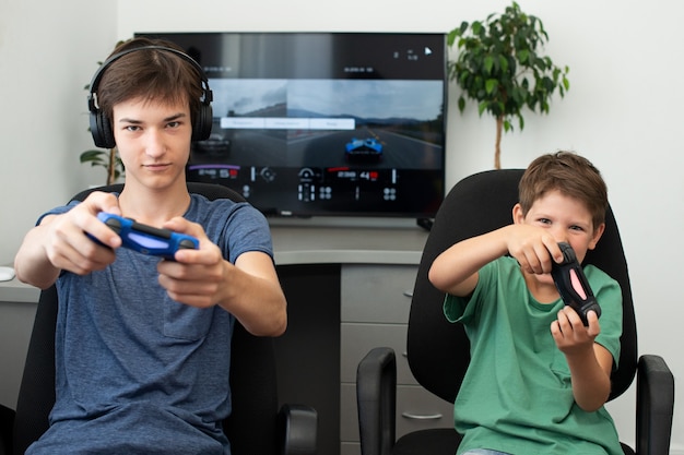 Adolescent joue à un jeu d'ordinateur avec des écouteurs et un joystick