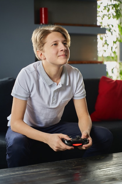 Photo un adolescent joue à un jeu vidéo en quarantaine