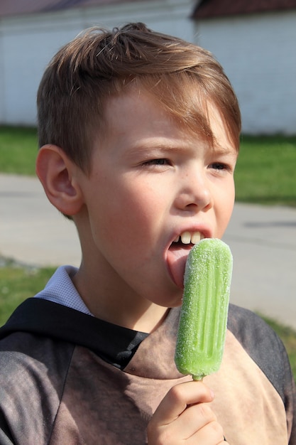 Un adolescent lèche la crème glacée.