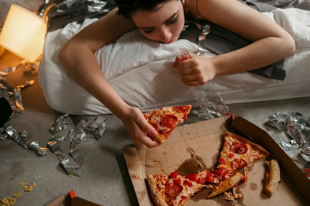 Photo adolescent mangeant une pizza pour réduire l'effet de la gueule de bois