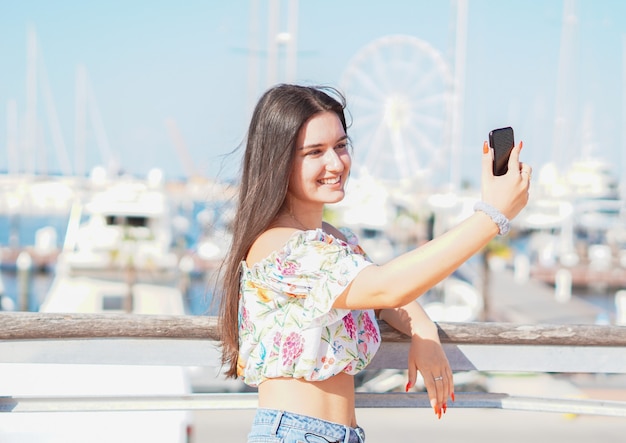 Adolescent prenant selfie à la plage - Jeune fille tenant l'appareil photo du smartphone pour prendre une photo d'elle-même pendant ses vacances d'été