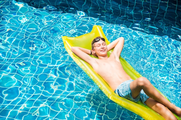 Adolescent relaxant avec matelas de piscine