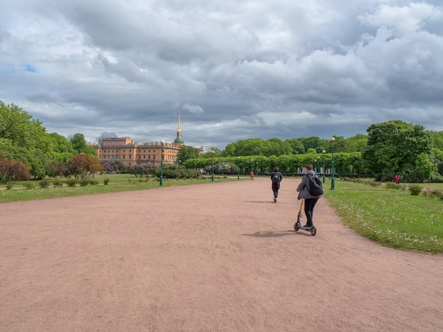 Un adolescent sur un scooter dans un parc de la ville