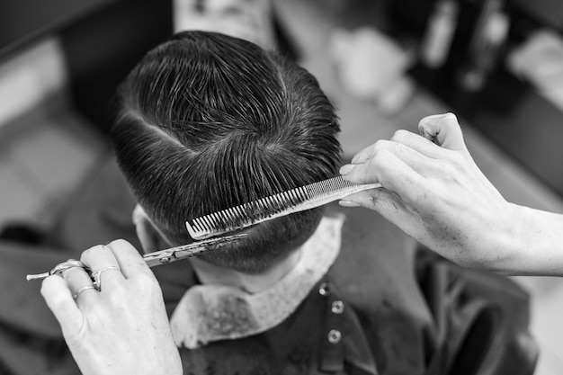 Un adolescent se fait couper les cheveux pendant une pandémie à la coupe de cheveux du salon de coiffure et sèche les cheveux après une coupe de cheveux