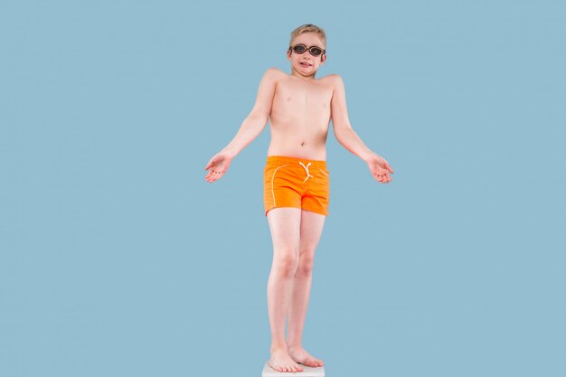 Adolescent en short orange et lunettes de natation