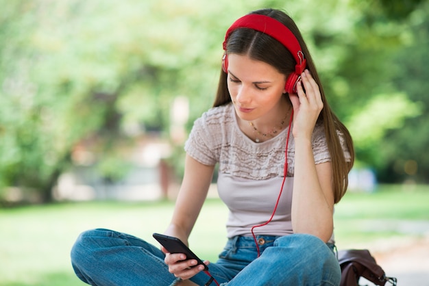 Adolescent souriant écoute de la musique depuis un téléphone