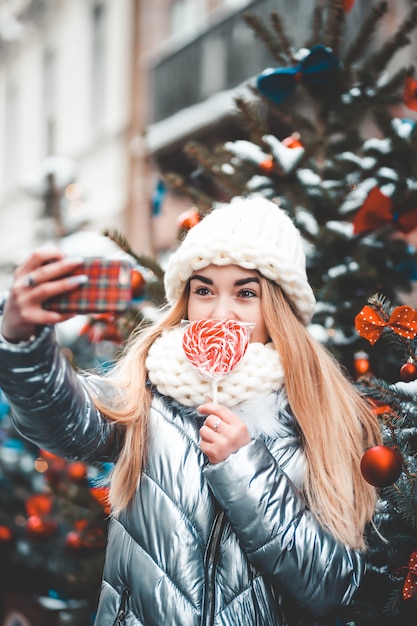 adolescent avec sucette faisant selfie avec l'arbre de Noël