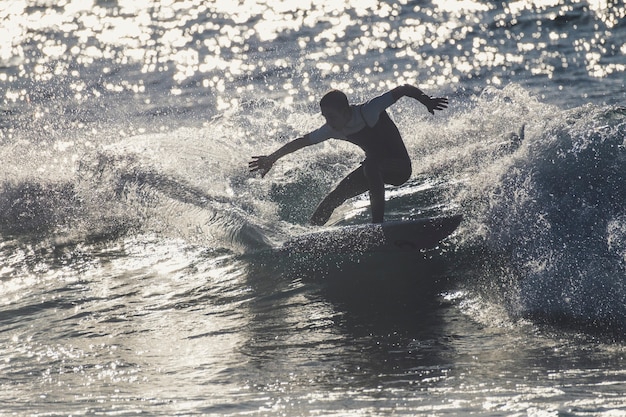 Adolescent surfant à la vague à tenerife playa de las americas - combinaisons blanches et belle et parfaite vague