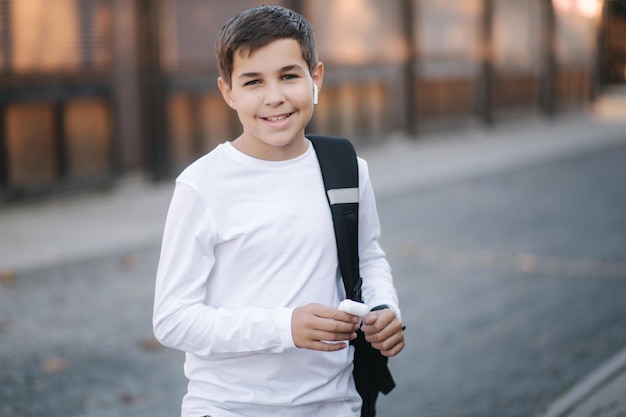 Un adolescent utilise des écouteurs sans fil pour écouter de la musique