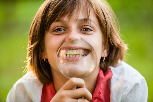 Un adolescent utilise une loupe pour découvrir la nature