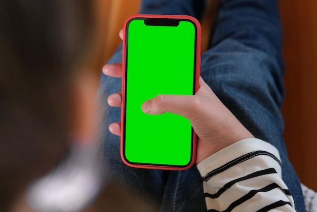 Adolescente de 12 ans avec sac à dos tient un écran vert de téléphone portable chromakey Publicité Éducation des applications pour enfants apprendre une langue étrangère Écolier montrant un écran vert de smartphone