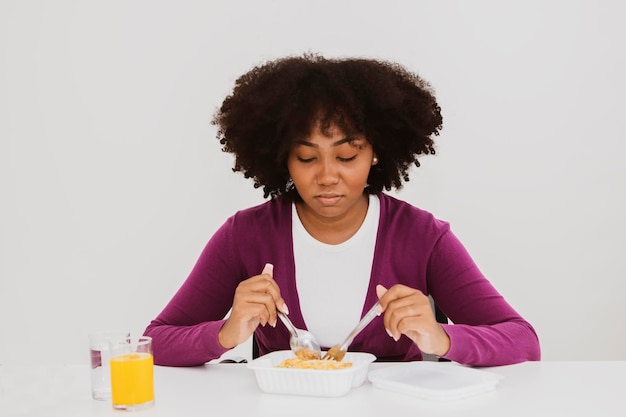 Une adolescente afro-américaine est fatiguée des repas préemballés monotones de graisses malsaines